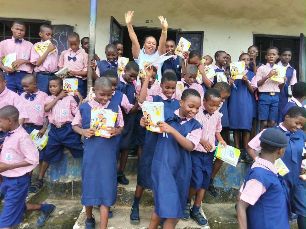 AWIMFI educational outreach distributing exercise books to junior secondary school students